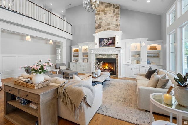 2917 Old Farm Road Washington, UT 84780 - Photo 16 of 105 Living room with a stone fireplace, lofted ceiling, wood finished floors, a decorative wall, and suspended lighting