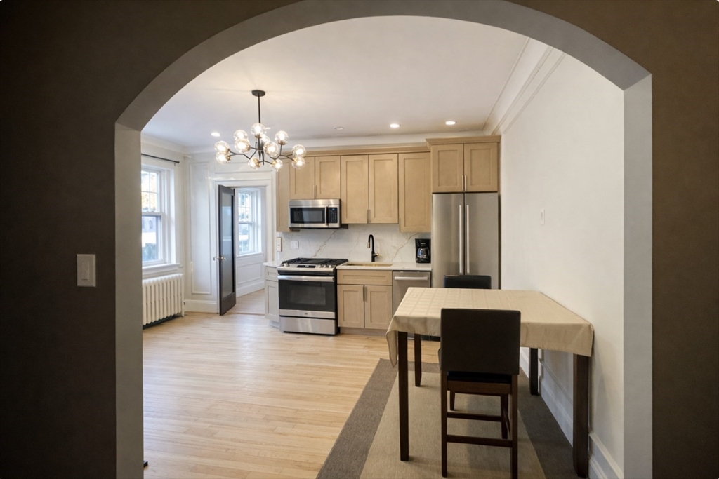 4 Chiswick Road, Unit 34 Boston, MA 02135 - Photo 3 of 10 a kitchen with kitchen island granite countertop a stove cabinets and a dining table