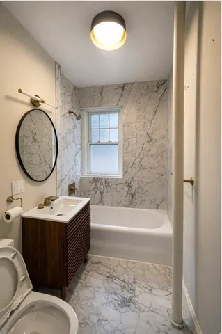 a bathroom with a tub sink and mirror