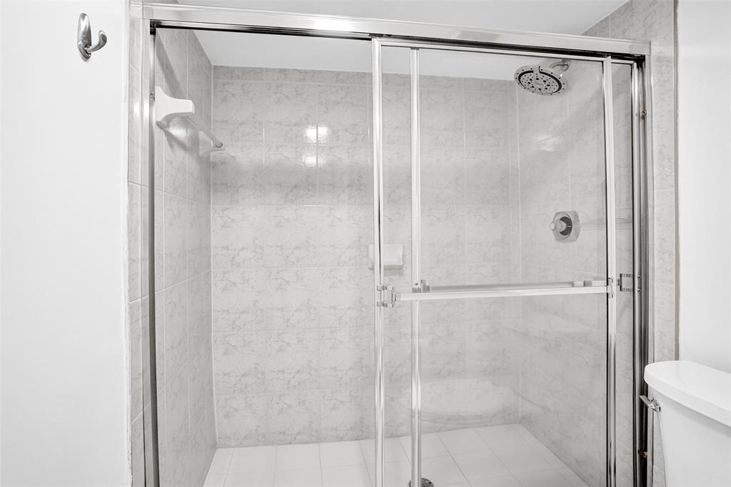9470 Tangerine Place, Unit 404 Davie, FL 33324 - Photo 11 of 39 a bathroom with a glass shower door