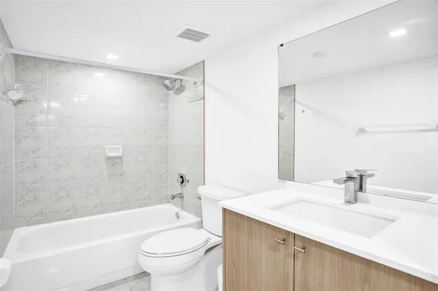 a bathroom with a sink a toilet and a large mirror