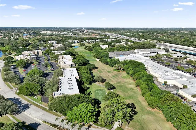 an aerial view of residential houses with outdoor space and trees