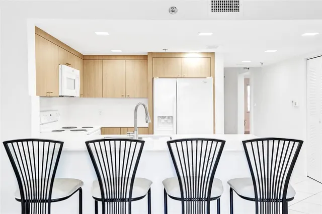 a kitchen with a table chairs and windows