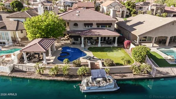 an aerial view of a house with swimming pool and a yard