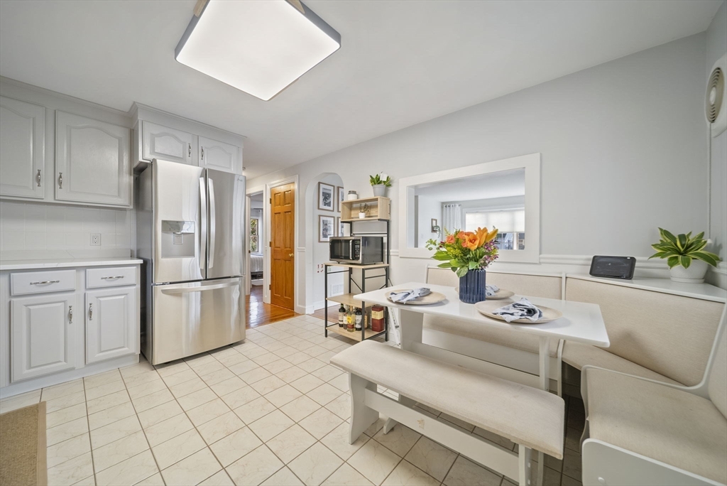 33 Ritchie Road Lynn, MA 01904 - Photo 10 of 39 a kitchen with a white refrigerator a stove a dining table and chairs