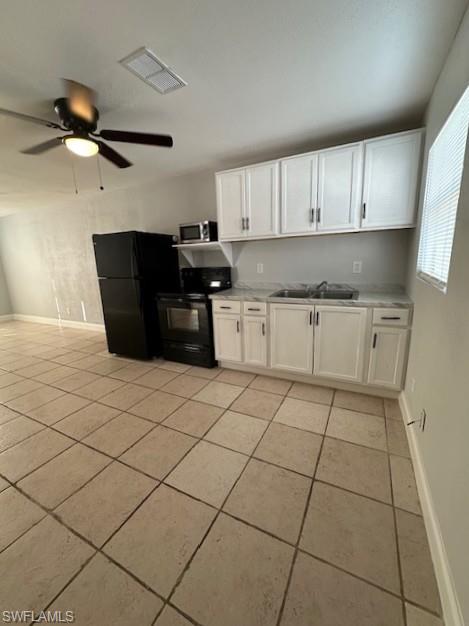 2964 Francis Avenue, Unit 13 Naples, FL 34112 - Photo 2 of 5 Kitchen with white cabinets, black appliances, light countertops, light tile patterned floors, and ceiling fan