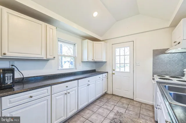 a kitchen with granite countertop a sink stainless steel appliances and cabinets
