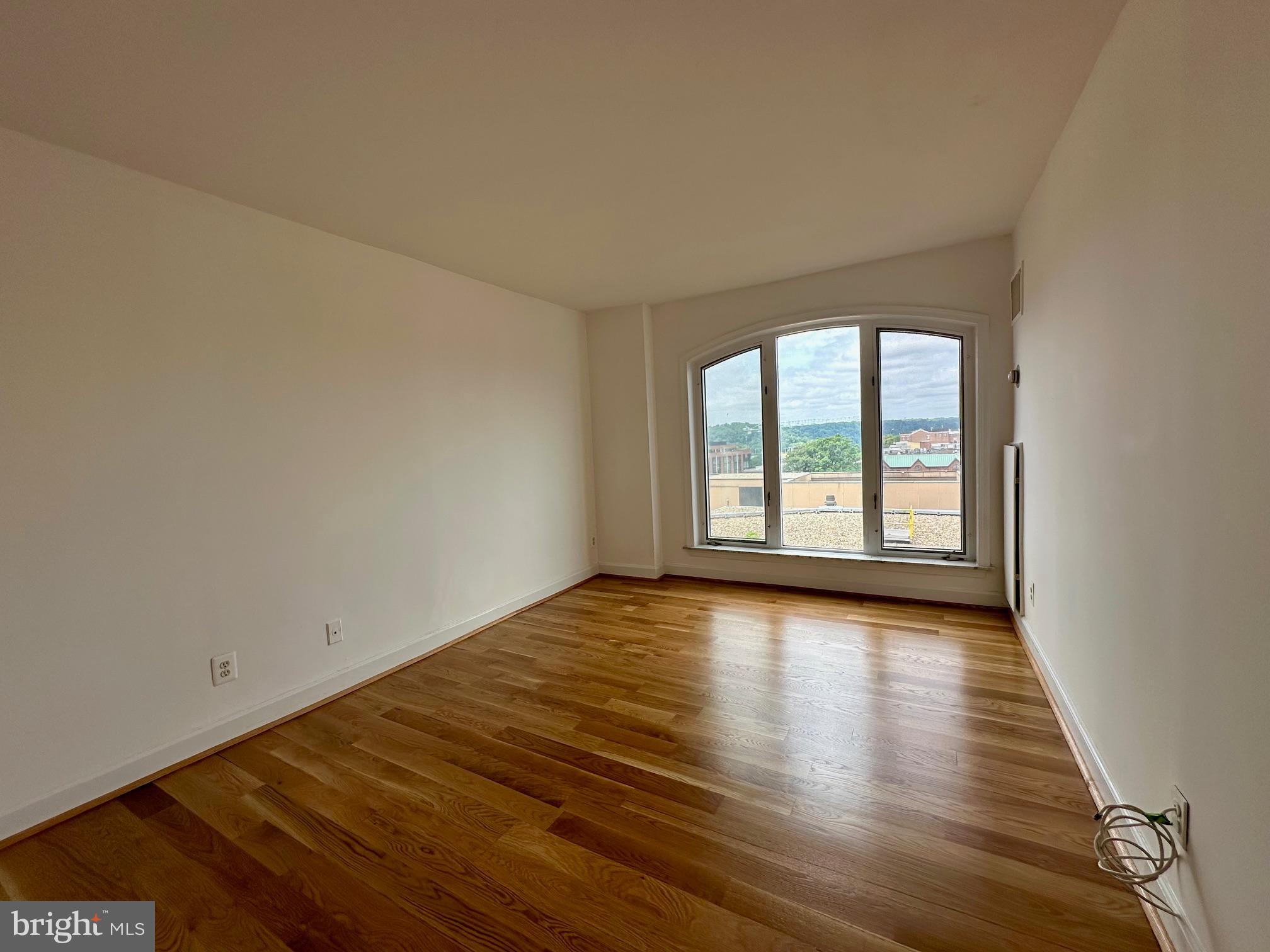 1080 Wisconsin Avenue Northwest, Unit 503W Washington, DC 20007 - Photo 22 of 36 wooden floor in an empty room with a window
