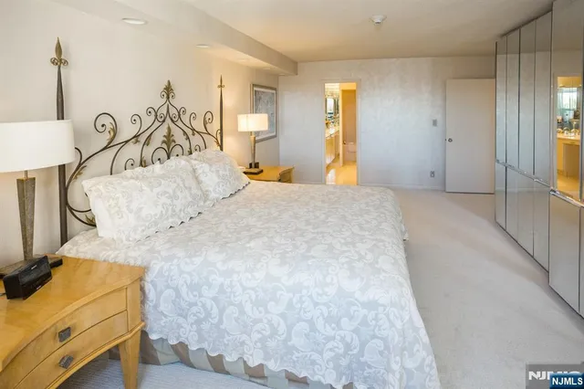 a bedroom with a bed and a flat tv screen on the dresser