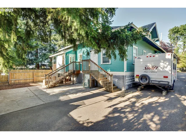 a view of a house with potted plants and a bench