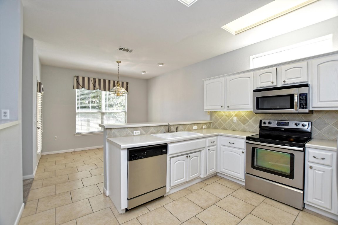 117 Beautybush Trail Georgetown, TX 78633 - Photo 11 of 25 a kitchen with a stove sink and microwave