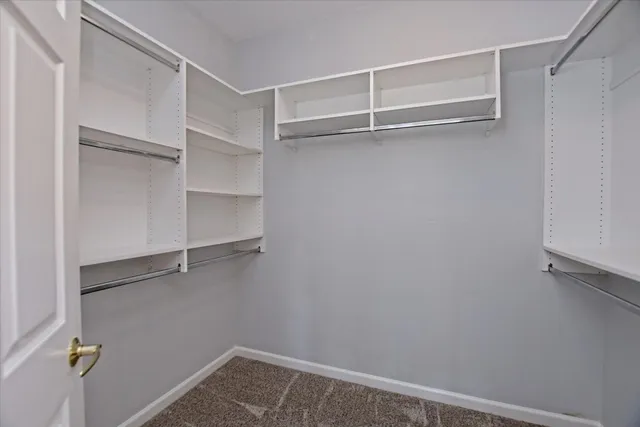 a view of walk in closet with empty racks
