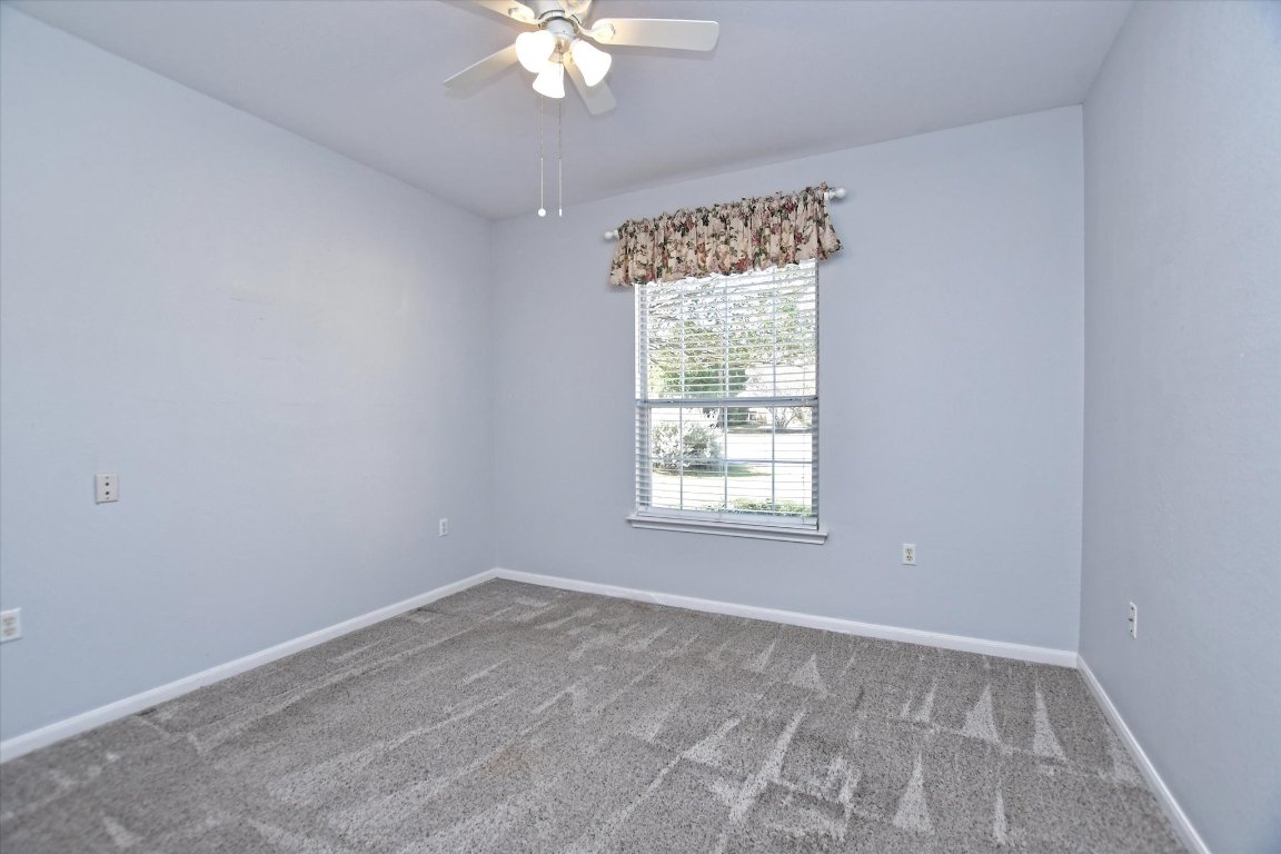 117 Beautybush Trail Georgetown, TX 78633 - Photo 19 of 25 an empty room with a chandelier fan and windows