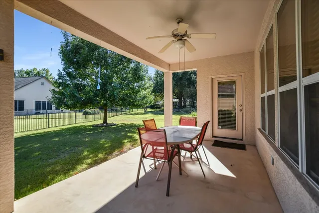 a view of a porch with a table chairs and a yard
