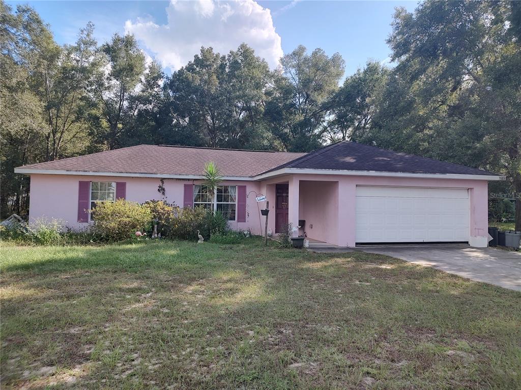 7688 Southwest 77 Place Ocala, FL 34476 - Photo 1 of 16 a view of a yard in front of a house with large tree