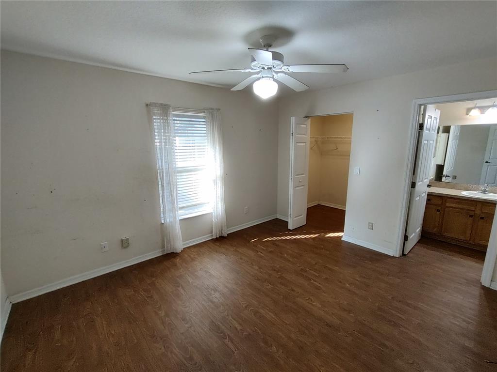 7688 Southwest 77 Place Ocala, FL 34476 - Photo 12 of 16 a view of a livingroom with wooden floor and a ceiling fan