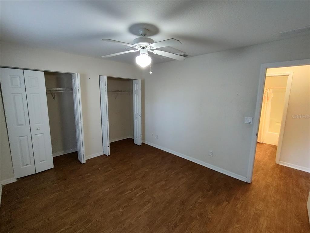 7688 Southwest 77 Place Ocala, FL 34476 - Photo 9 of 16 an empty room with wooden floor fan and windows