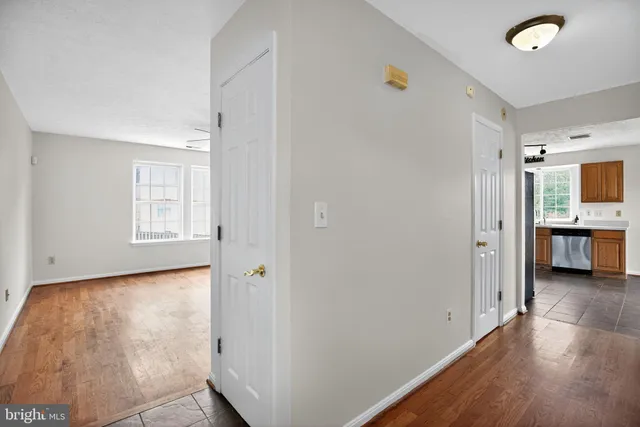 a view of a big room with wooden floor and windows