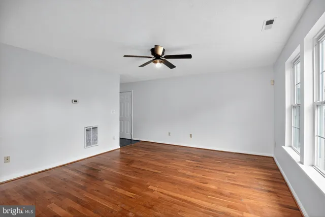 wooden floor in an empty room with a window