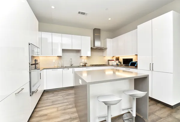 a kitchen with granite countertop a sink a stove and cabinets