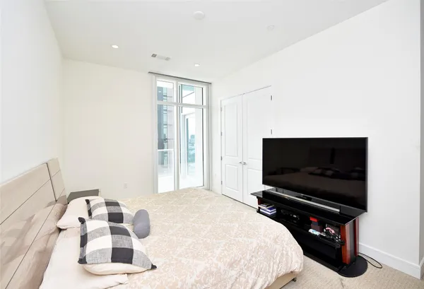 a bedroom with a bed and a large window