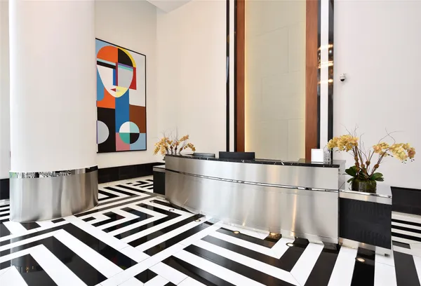 a hallway with a black white checkered floor and a flat screen tv