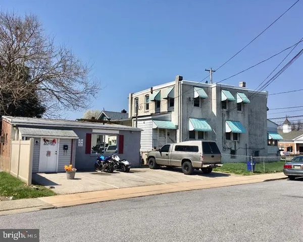 a front view of a building with cars parked