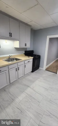 a kitchen with granite countertop a sink a stove and cabinets