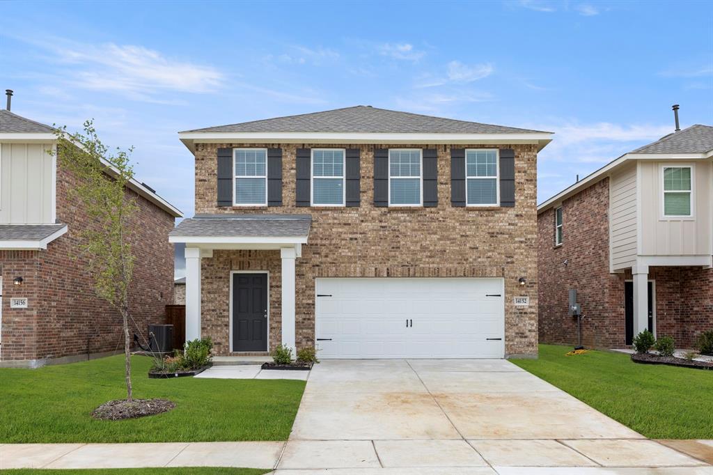 a front view of a house with a yard and garage