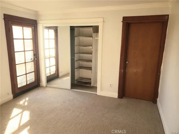 an empty room with windows and closet