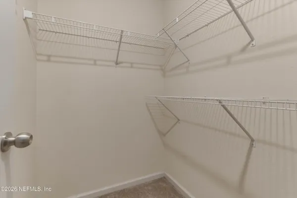 an empty room with windows and ceiling fan