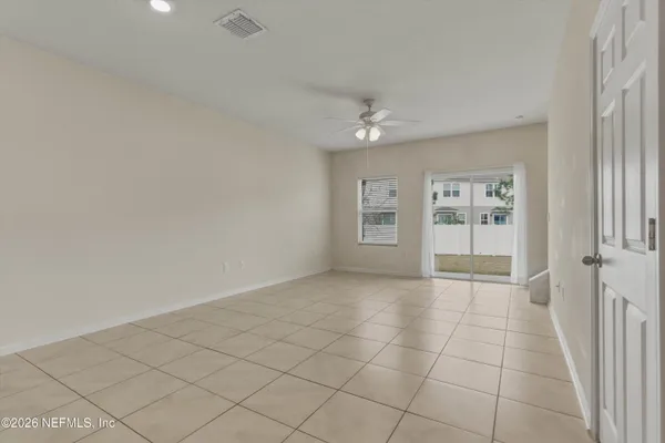 a view of an empty room and kitchen view