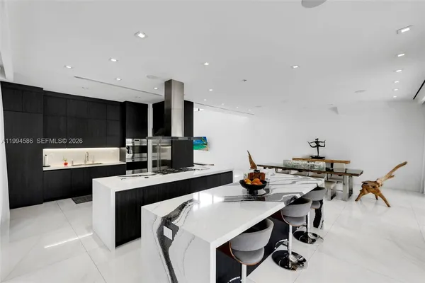 a kitchen with stainless steel appliances kitchen island granite countertop a refrigerator and a sink