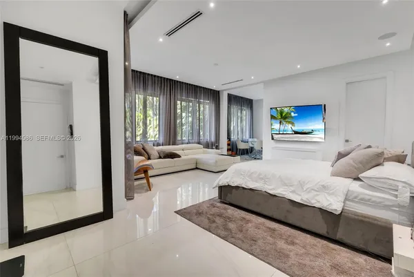 a living room with furniture a floor to ceiling window and a flat screen tv
