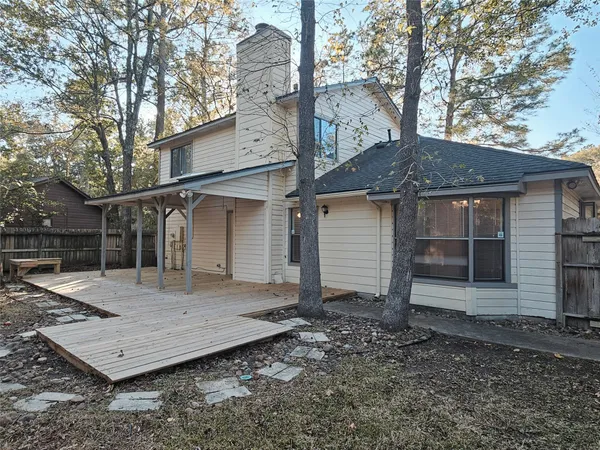 a view of a house with a yard and large tree