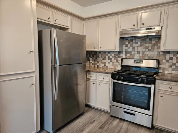 a white refrigerator freezer and a stove sitting inside of a kitchen