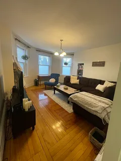 a living room with furniture and a chandelier