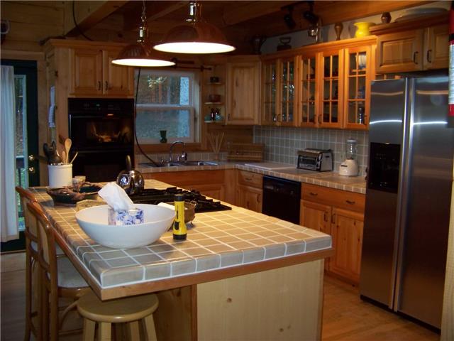 171 Love Lady Hollow Road Tennessee Ridge, TN 37178 - Photo 2 of 20 COMPLETE WITH TILED COUNTER TOPS, GLASS FRONT CABINETS AND A DOWN-DRAFT RANGE, PREPARING MEALS IN THIS KITCHEN IS A LABOR OF LOVE.