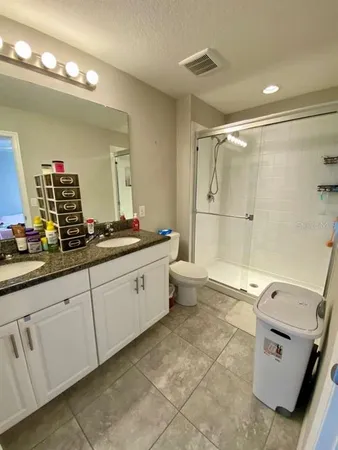 a spacious bathroom with a double vanity sink a mirror and a shower