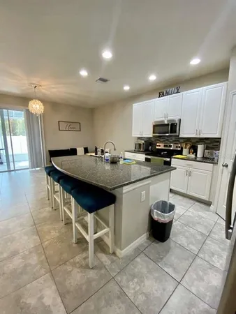 a kitchen with a sink a counter top space appliances and cabinets