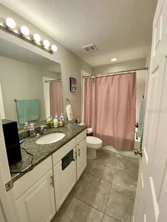 a spacious bathroom with a granite countertop sink and a mirror