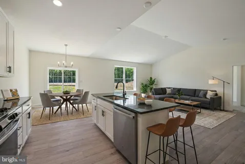 a kitchen with stainless steel appliances granite countertop table chairs stove and sink