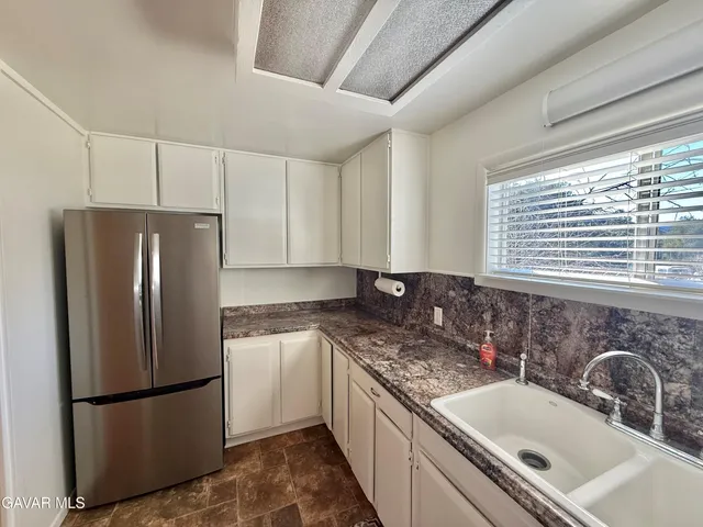 a kitchen with granite countertop a sink stove and cabinets