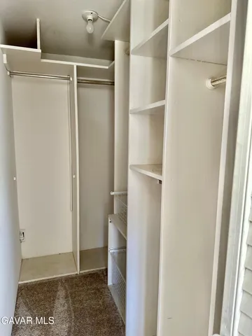 a view of walk in closet with empty racks
