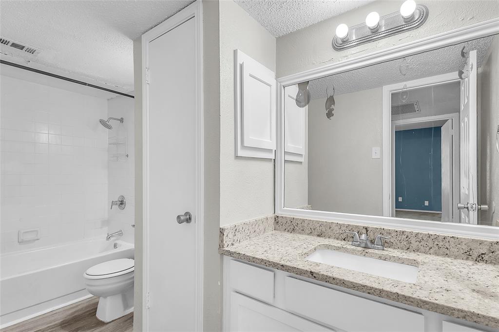 8109 Skillman Street, Unit 2007 Dallas, TX 75231 - Photo 11 of 11 a bathroom with a granite countertop sink toilet and shower