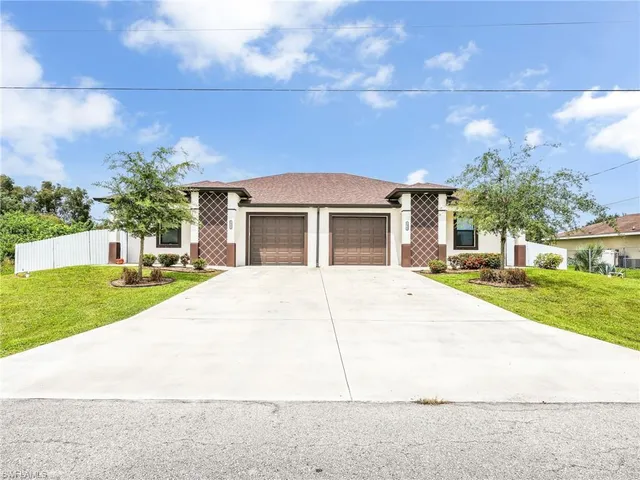 a front view of a house with a yard and garage