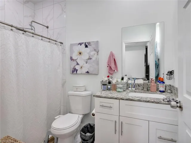 a bathroom with a sink vanity mirror and toilet
