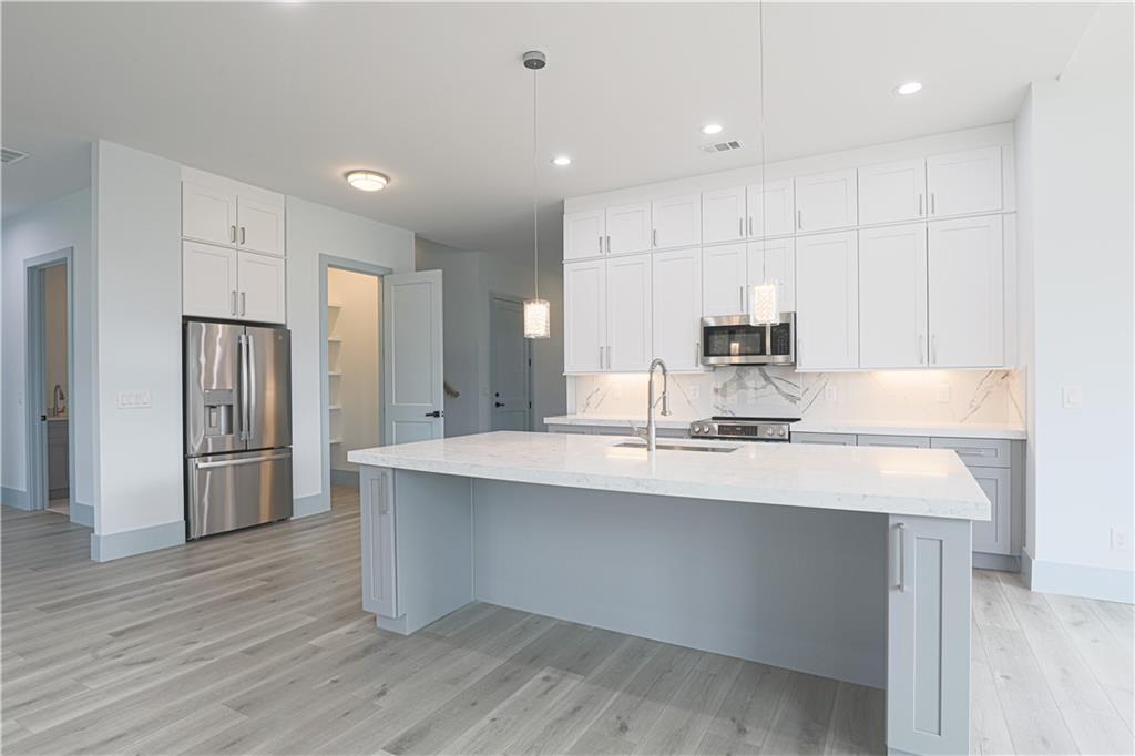 1480 Wheeler Cemetery Road Maysville, GA 30558 - Photo 23 of 50 a kitchen with kitchen island a sink stainless steel appliances and cabinets