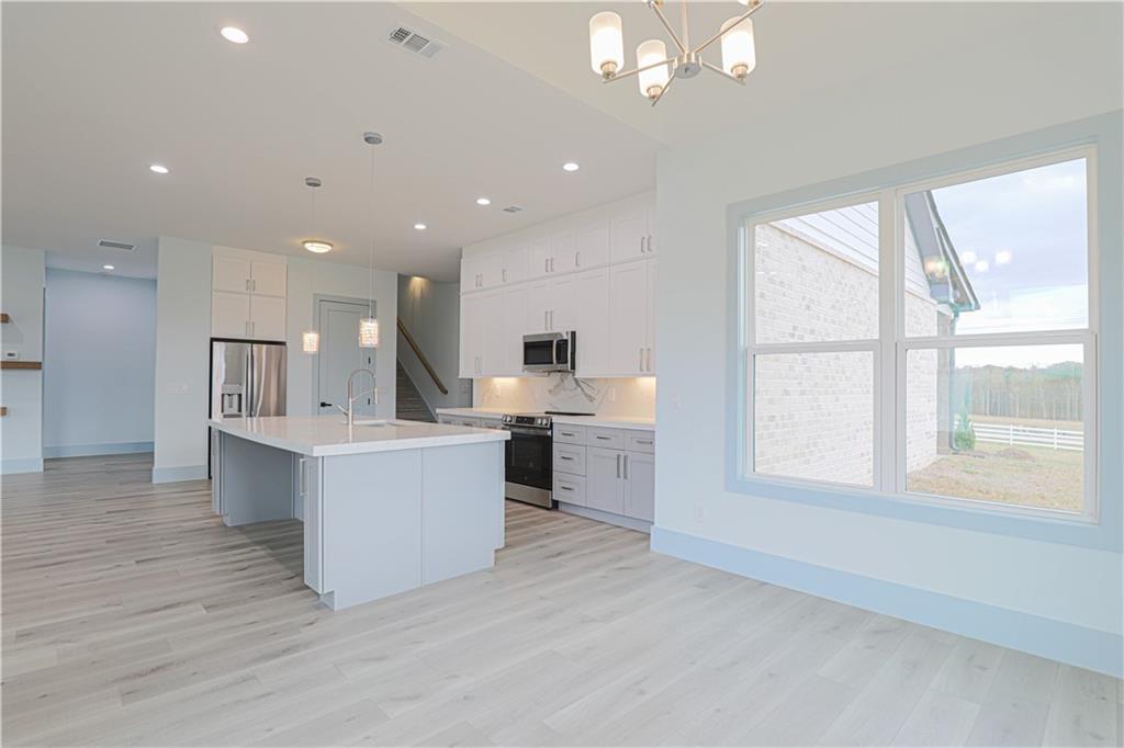 1480 Wheeler Cemetery Road Maysville, GA 30558 - Photo 24 of 50 a large white kitchen with a large window and stainless steel appliances