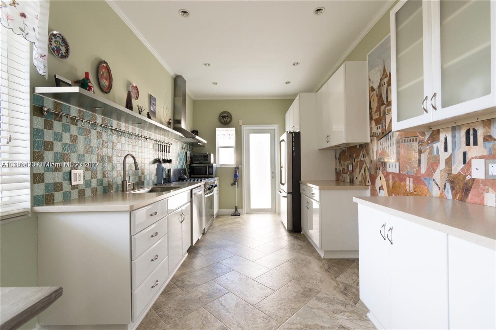 9033 Byron Avenue Surfside, FL 33154 - Photo 11 of 25 a kitchen with granite countertop a sink and cabinets